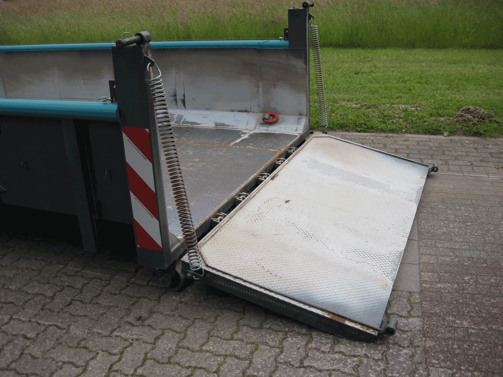 Geöffnete Containerklappe mit Metallrampe zum Be- und Entladen – Bild für barrierearmes Befüllen eines Containers