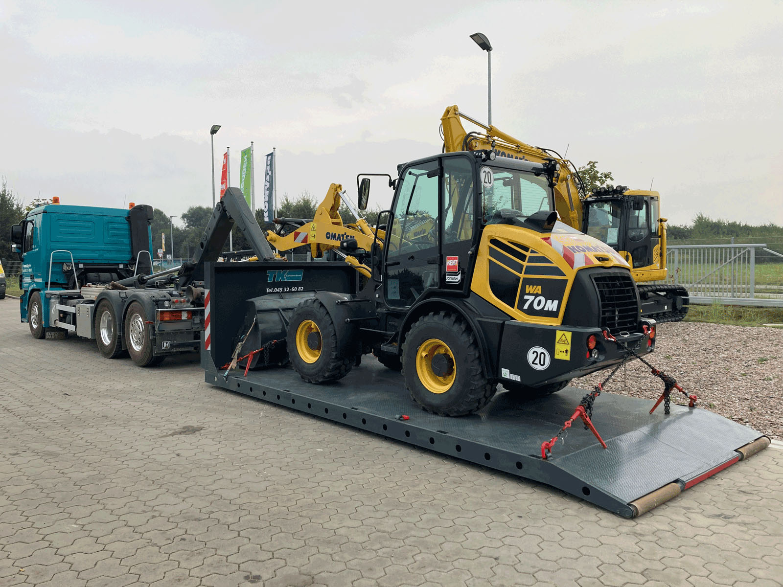 Plateaucontainer mit verladenem Radlader und gesicherter Ladung, bereit für den Transport – Bild für Maschinentransport in Schleswig-Holstein