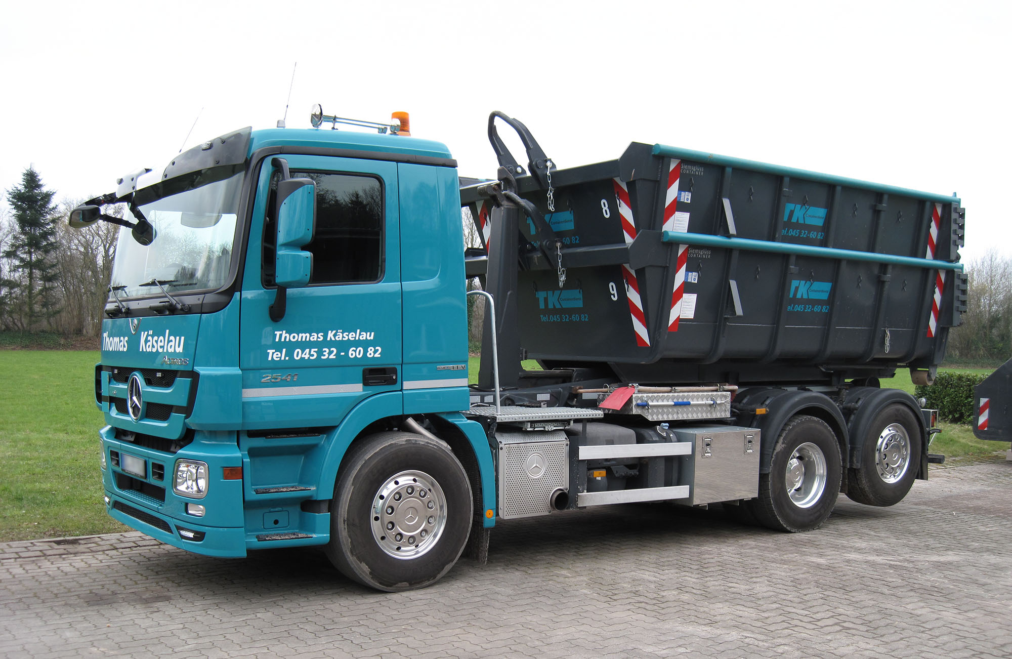 Absetzfahrzeug mit mehreren geschlossenen Containern für die Abfallentsorgung im Außenbereich – Bild für Entsorgung und Containerbereitstellung in Schleswig-Holstein