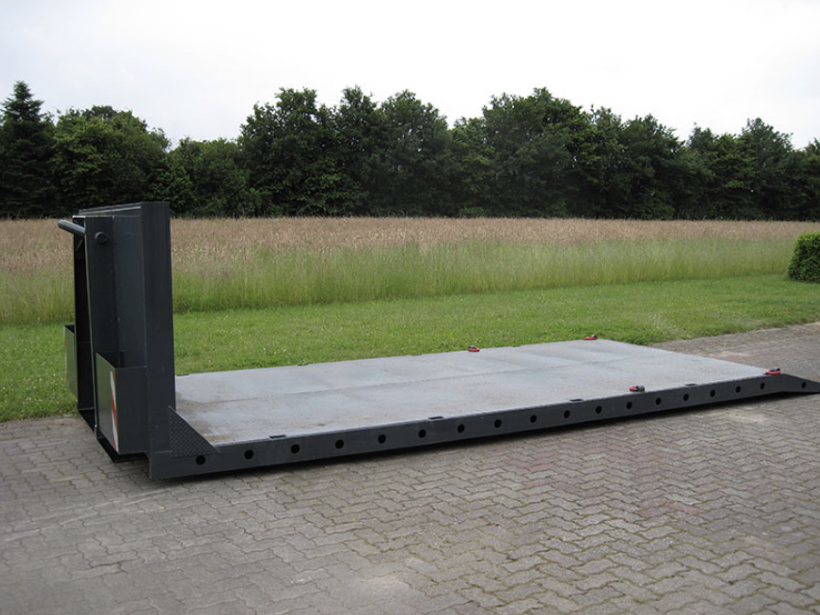 Plateaucontainer mit flacher Ladefläche auf einem Hof – geeignet für Maschinentransport und sperrige Güter in Schleswig-Holstein